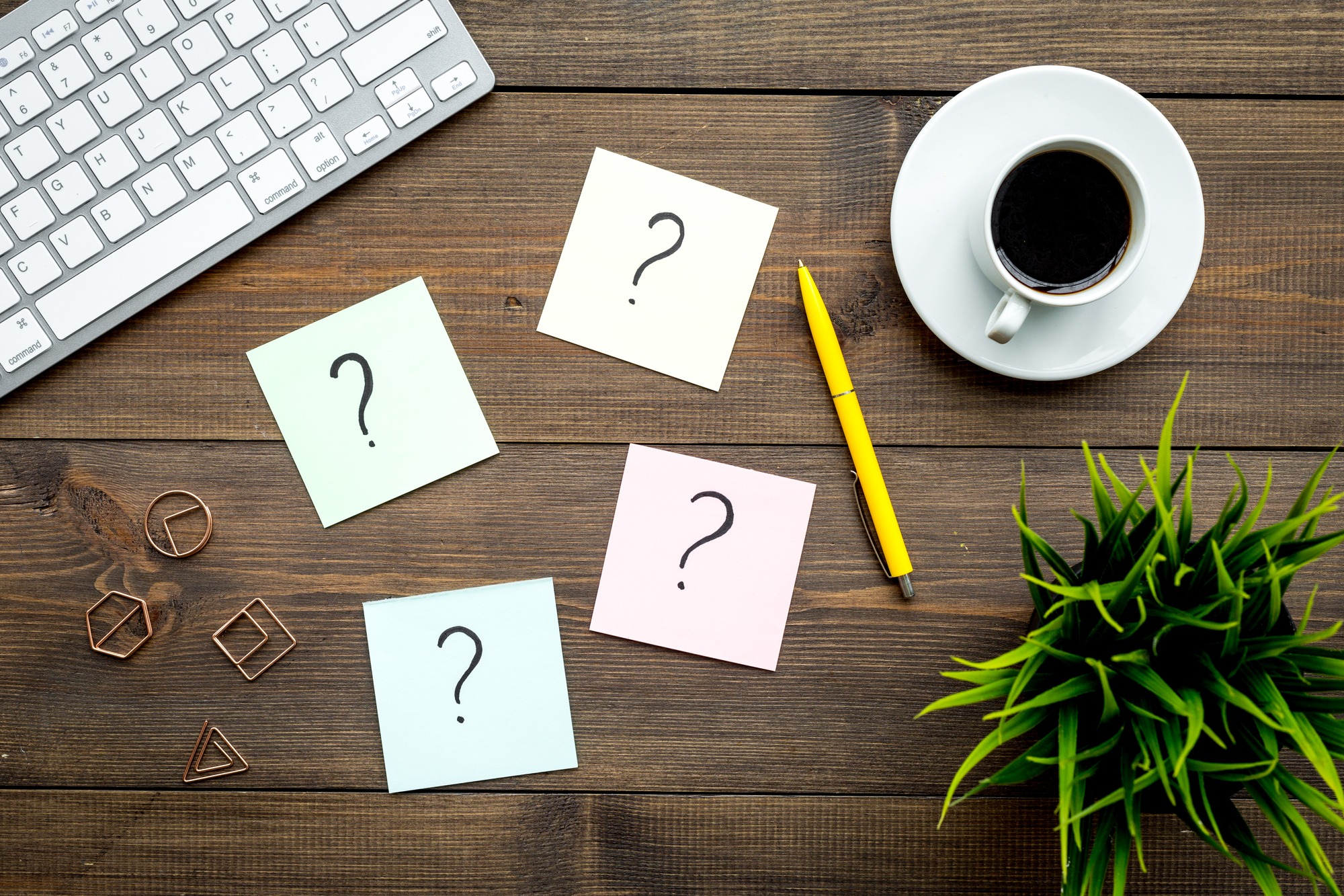 Question Mark on Sticky Notes on Office Desk on Dark Wooden Background Top View